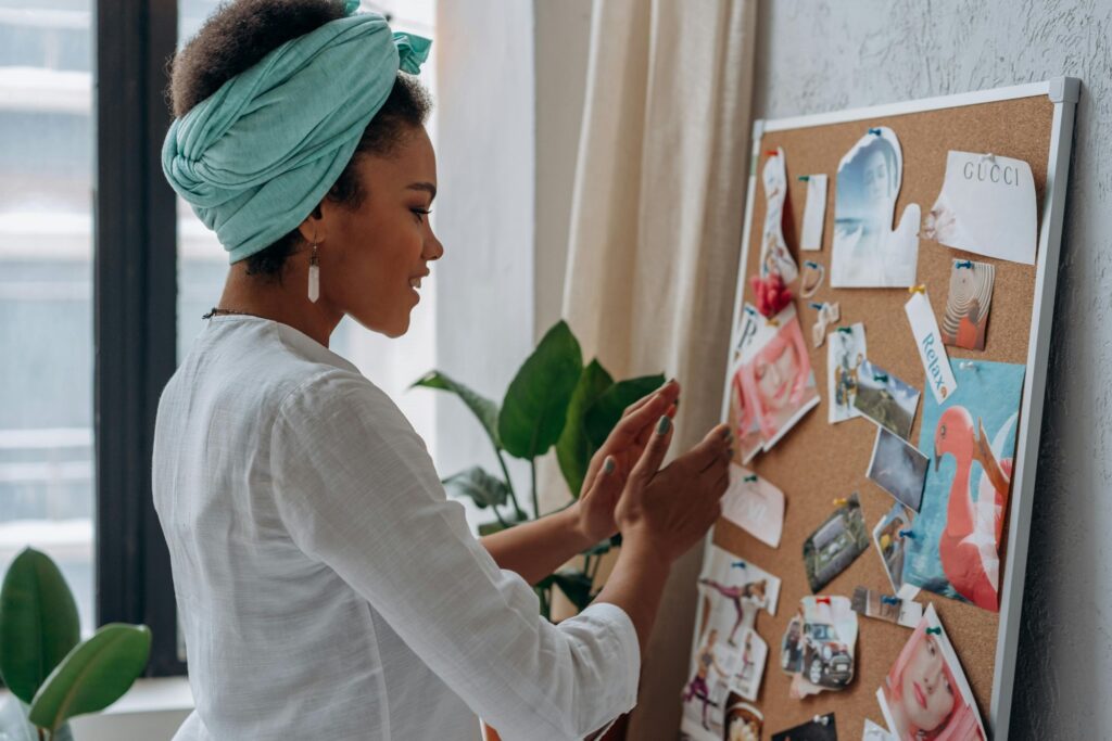 A woman creating a vision board illustrating one of the ways you can rewire your subconscious mind for success.