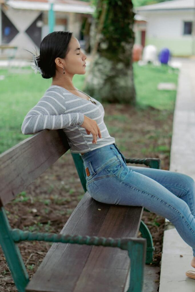 Woman sitting in a park bench by herself practicing self-discovery.