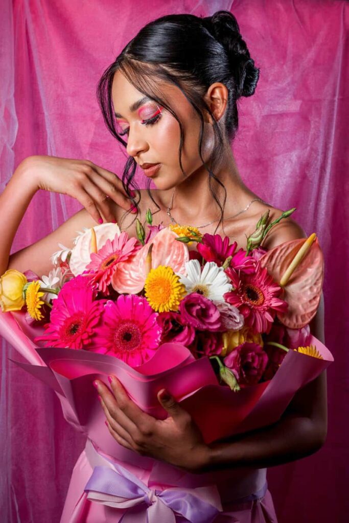 A woman in a pink dress with a floral bouquet in front represents a feminine Approach to a mid-year reset 