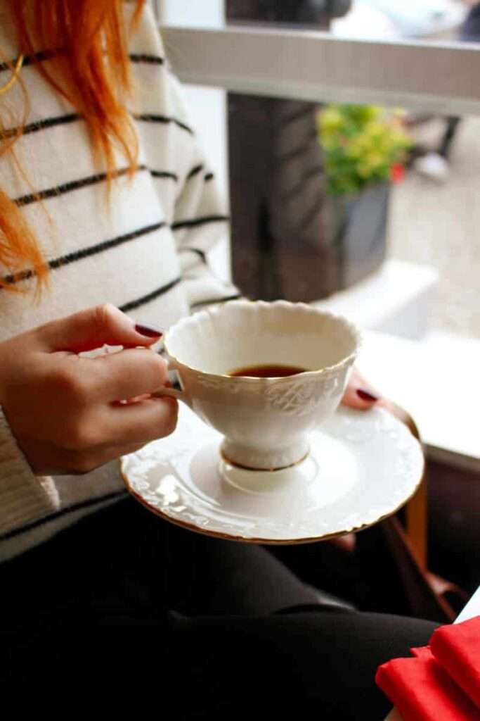 Woman holding a teacup representing a soft Sunday reset ritual 