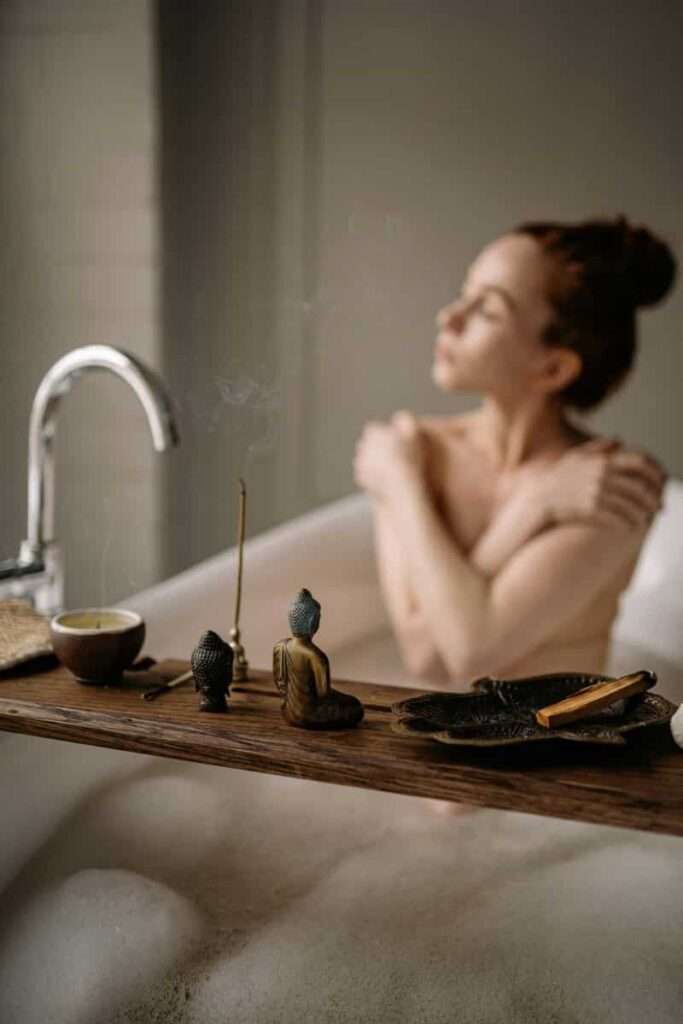 Image of a woman in a bathtub with candles and the mood set, representing self-care as an end-of-the-year ritual.